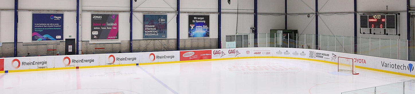 Innenansicht einer Eishalle mit Eisfläche, Werbebanden und einer Anzeigetafel mit 40:00 und 0:0